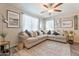 Bright living room boasts a large sectional sofa, ceiling fan, and a stylish entertainment center at 8043 W Albeniz Pl, Phoenix, AZ 85043