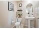 Cute half bathroom features a pedestal sink, decorative mirror, and stylish decor at 8043 W Albeniz Pl, Phoenix, AZ 85043