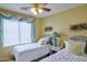Bright guest bedroom featuring twin beds, yellow walls, and a window with light blue accents at 8242 S Kachina Dr, Tempe, AZ 85284