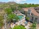 Backyard featuring a swimming pool, outdoor kitchen, fire pit, stone patio, palm trees, and lounge chairs at 8540 E Mcdowell Rd # 10, Mesa, AZ 85207