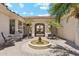 Picturesque courtyard with a fountain, pavers, palm trees, lounge chairs, and covered seating area at 8540 E Mcdowell Rd # 10, Mesa, AZ 85207