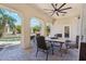 Inviting covered patio with a ceiling fan, table set, and views of the pool and lush greenery beyond the arches at 8540 E Mcdowell Rd # 10, Mesa, AZ 85207
