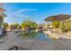 Inviting backyard pool area with mature landscaping and an umbrella for shade and a built in bar with seating at 8540 E Mcdowell Rd # 10, Mesa, AZ 85207