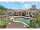 Beautiful backyard pool surrounded by desert landscaping, with a view of the home's exterior and tile roof at 8540 E Mcdowell Rd # 10, Mesa, AZ 85207