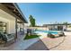 Beautiful backyard pool area featuring lounge seating, gravel landscaping, and a covered patio area at 8714 E Mackenzie Dr, Scottsdale, AZ 85251