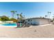Resort-style backyard with a sparkling pool, sun loungers, and lush palm trees for ultimate relaxation at 8714 E Mackenzie Dr, Scottsdale, AZ 85251