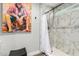 Shower area with stylish marble-patterned tile and modern fixtures, complemented by unique artwork at 8714 E Mackenzie Dr, Scottsdale, AZ 85251