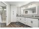 Elegant bathroom featuring dual sinks, framed mirror, white cabinetry, and a beautifully tiled shower at 8714 E Mackenzie Dr, Scottsdale, AZ 85251