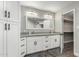 Bright bathroom features dual sinks, elegant white cabinetry, and a walk-in closet for ample storage at 8714 E Mackenzie Dr, Scottsdale, AZ 85251