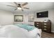 Bright main bedroom features a ceiling fan, TV, and an en-suite bathroom for added convenience at 8714 E Mackenzie Dr, Scottsdale, AZ 85251