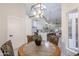 Open dining area featuring modern lighting fixtures, a kitchen view, and a round wooden table set at 8941 E Maple Dr, Scottsdale, AZ 85255