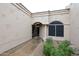 Covered entrance with arched entryway, neutral color scheme, and desert landscaping at 8941 E Maple Dr, Scottsdale, AZ 85255