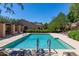 Community pool surrounded by lounge chairs, landscaping, and shade canopies at 8941 E Maple Dr, Scottsdale, AZ 85255
