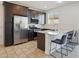 Modern kitchen with stainless steel appliances, tile backsplash and island seating at 9310 W Atlantis Way, Tolleson, AZ 85353
