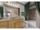 Classic bathroom with a wooden vanity, mirror, decorative wallpaper, and shower/tub combo with green curtains at 11360 E Keats Ave # 70, Mesa, AZ 85209
