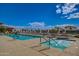 Relaxing community pool and hot tub with many lounge chairs under a blue sky and scattered clouds at 11360 E Keats Ave # 70, Mesa, AZ 85209