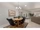 Cozy dining room with a wood table, chandelier, and comfortable seating adjacent to the living room with view to backyard at 11360 E Keats Ave # 70, Mesa, AZ 85209