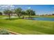 Golf course pond with fountains surrounded by manicured green grass under a partly cloudy sky at 11360 E Keats Ave # 70, Mesa, AZ 85209