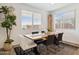 A bright dining room with natural light, showcasing a rustic wooden table, stylish chairs, and modern decor at 12269 E Chiricahua Pl, Gold Canyon, AZ 85118