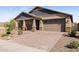 Welcoming home featuring a brick-paved driveway, desert landscaping, and a two-car garage at 12269 E Chiricahua Pl, Gold Canyon, AZ 85118
