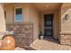 Inviting front entry with stone accents, potted plants, and stylish front door at 12269 E Chiricahua Pl, Gold Canyon, AZ 85118