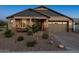 Charming home exterior with manicured landscaping, stone accents, and a two-car garage at 12269 E Chiricahua Pl, Gold Canyon, AZ 85118