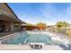 Inviting hot tub with waterfall feature surrounded by patio furniture for outdoor relaxation and entertainment at 12269 E Chiricahua Pl, Gold Canyon, AZ 85118