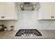 A close-up of a kitchen featuring a gas cooktop, diamond-patterned backsplash, and granite countertop at 12269 E Chiricahua Pl, Gold Canyon, AZ 85118