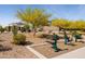 Neighborhood park featuring exercise equipment surrounded by gravel and mature trees at 12269 E Chiricahua Pl, Gold Canyon, AZ 85118