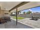 Backyard featuring a covered patio, dining set, artificial turf and gravel at 12447 N 50Th Ln, Glendale, AZ 85304