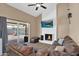 Cozy living room showcasing a brick fireplace, ceiling fan, and sliding glass door to the backyard at 12447 N 50Th Ln, Glendale, AZ 85304