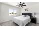 Cozy bedroom with a ceiling fan, plush carpet, and a large window at 12506 W Corrine Dr, El Mirage, AZ 85335