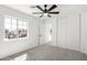 Bright bedroom featuring a ceiling fan, closet, and a window with neighborhood views at 12506 W Corrine Dr, El Mirage, AZ 85335