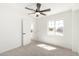 Bright bedroom with a ceiling fan and a window overlooking neighborhood views at 12506 W Corrine Dr, El Mirage, AZ 85335