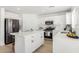 Bright white kitchen featuring stainless steel appliances, island, and modern finishes at 12506 W Corrine Dr, El Mirage, AZ 85335