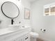 Modern powder room featuring stylish sink, vanity, toilet, and decorative mirror at 12506 W Corrine Dr, El Mirage, AZ 85335
