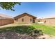 A large backyard with mature landscaping including grass and rock at 13145 W Cambridge Ave, Goodyear, AZ 85395