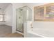 Bathroom features a glass-enclosed shower, soaking tub, and wood shutter windows at 13145 W Cambridge Ave, Goodyear, AZ 85395