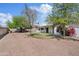The backyard features a large gravel area, mature trees, and a charming neutral exterior at 13816 N 46Th St, Phoenix, AZ 85032