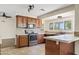 A view of the kitchen showcasing stainless appliances, wood cabinets, and a tile backsplash at 13816 N 46Th St, Phoenix, AZ 85032