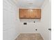 Small laundry room features tile flooring and overhead wood cabinets at 13816 N 46Th St, Phoenix, AZ 85032