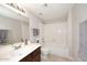 Bright bathroom featuring a shower-tub combo, a vanity with dark wood cabinets, and neutral-toned tile flooring at 14002 N 49Th Ave # 1040, Glendale, AZ 85306