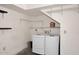 Well-lit laundry room featuring a modern washer and dryer with shelving units for convenient storage at 14002 N 49Th Ave # 1040, Glendale, AZ 85306