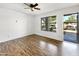 Comfortable bedroom with wood-style flooring, bright lighting, and a view to the parking area at 1440 N Idaho Rd # 1048, Apache Junction, AZ 85119