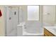 Bright bathroom featuring a walk-in shower and a separate soaking tub beneath a window at 15339 W Jefferson St, Goodyear, AZ 85338