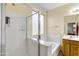 Clean bathroom with a walk-in shower, separate tub, and ample natural light at 15339 W Jefferson St, Goodyear, AZ 85338