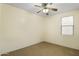 This bedroom features neutral walls, carpeted floors, a ceiling fan, and natural light from the window at 15339 W Jefferson St, Goodyear, AZ 85338