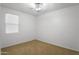 A simple bedroom with tan carpet, a window, and a ceiling fan at 15339 W Jefferson St, Goodyear, AZ 85338