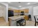 Spacious kitchen with stainless appliances, wood cabinetry, and an island with seating at 15339 W Jefferson St, Goodyear, AZ 85338