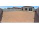 Expansive dirt backyard, enclosed by block wall fencing and a small patio, perfect for designing your dream outdoor space at 18052 W Sand Hills Rd, Surprise, AZ 85387